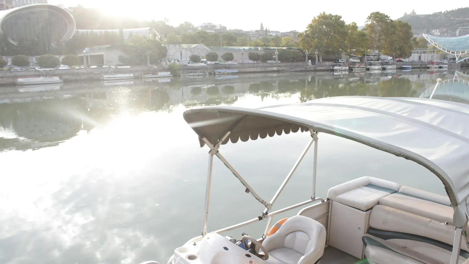 A pontoon boat on flat water in low early morning light