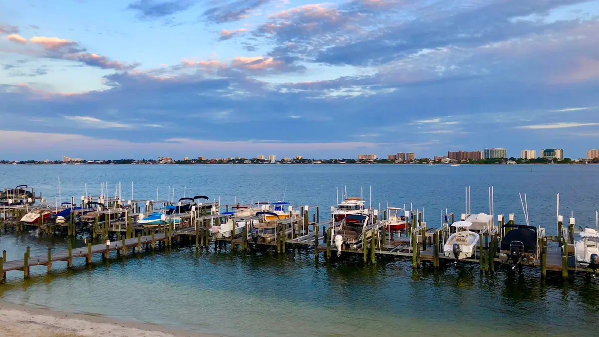 Boats tied along a dock in a sheltered marina basin