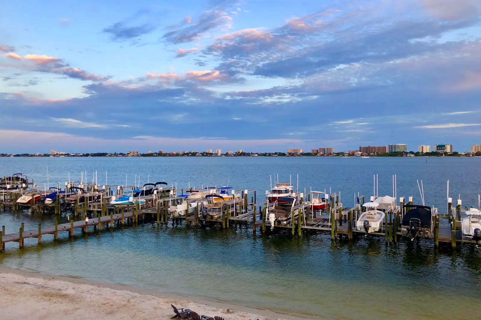 Boats moored along a waterfront dock under a bright sky