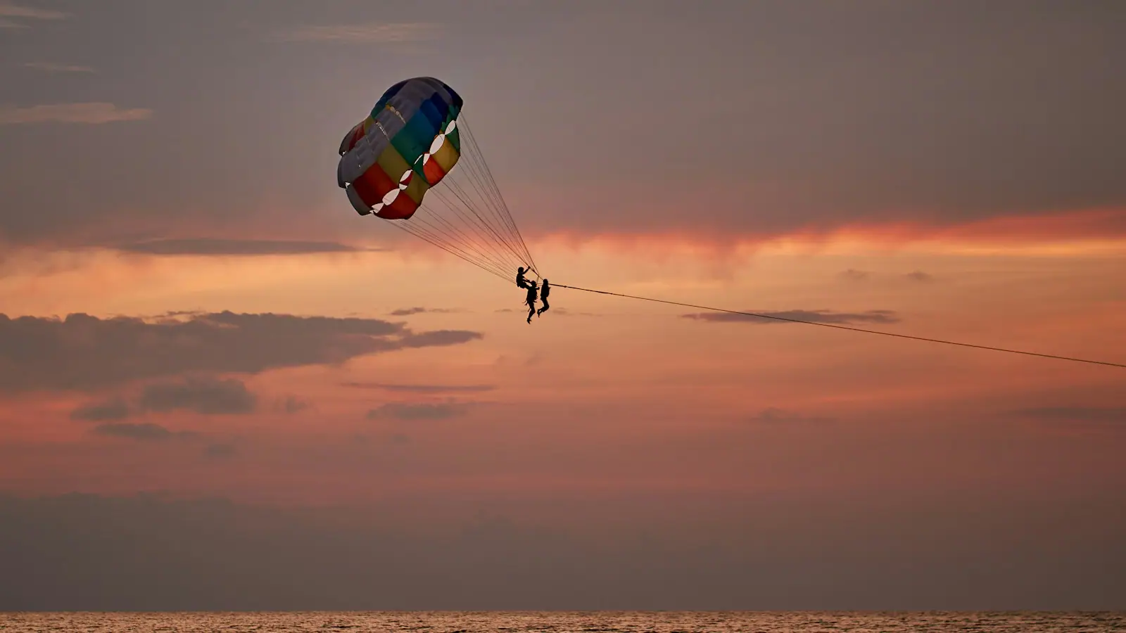 A parasail canopy hanging above the ocean in late afternoon light