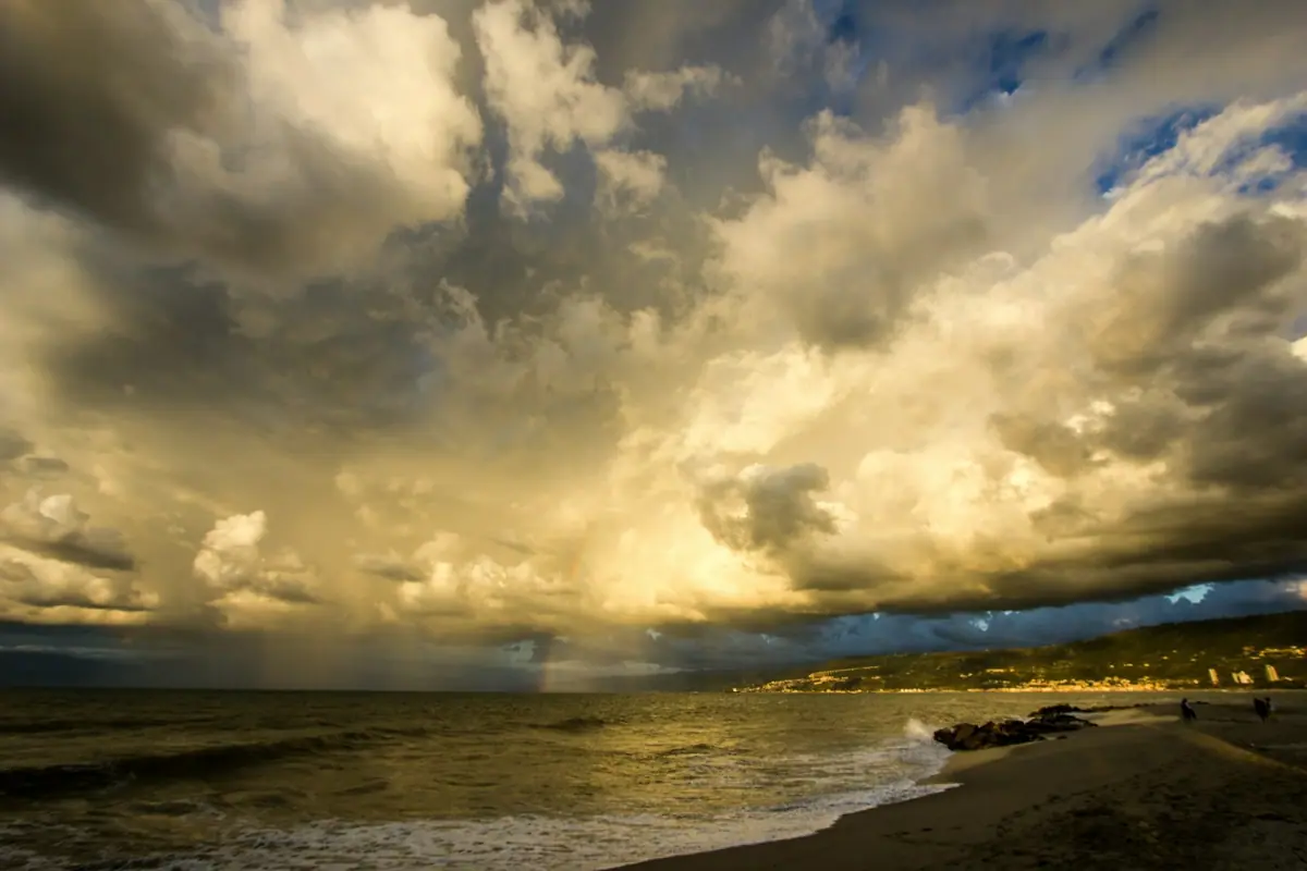Heavy cloud over the sea with a wide empty beach in the foreground
